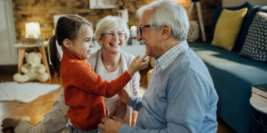 Cute small girl spending time with her grandparents at home.